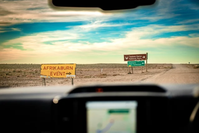 The gravel road to Tankwa Town (R355) hasn’t changed since last year. It’s still a deceptive, tyre-shredding stretch that doesn’t care about your 4x4. If anything, it’s hungrier.

- Check your tyres before you start your journey. The Tyre Tax is real, and the desert collects from the overconfident.
- Stick to 70 km/h max. Speed & weight slices sidewalls.
- Two spares if you can. Check your jack isn’t buried under tents and tequila.

Don’t be a rally driver. Overtaking in a dust cloud is how you meet a ditch. Take it easy and arrive with all four wheels still attached.

Photo: Benoit Darud