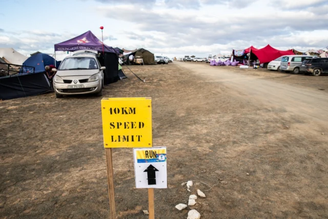 Howzit! Let’s talk about speed. Ground speed. The speed limit at AfrikaBurn is 10 km/h for everyone. That means mutants, micycles, bicycles, tricycles, dusty unicycles, and whatever the fok that beautiful glowing contraption is. If it’s on wheels, it’s limited to 10 km/h. Please slow down.

When you arrive, please park your vehicle at your campsite and leave it there until it’s time to go home. Don’t leave cars standing in the roads, on corners, or blocking access routes.
Even when a road looks quiet, it’s still a road and not a campsite.

Photo: Jonx Pillemer